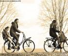 Счастливые семьи велосипедов, прогуливаясь по парку в зимний период